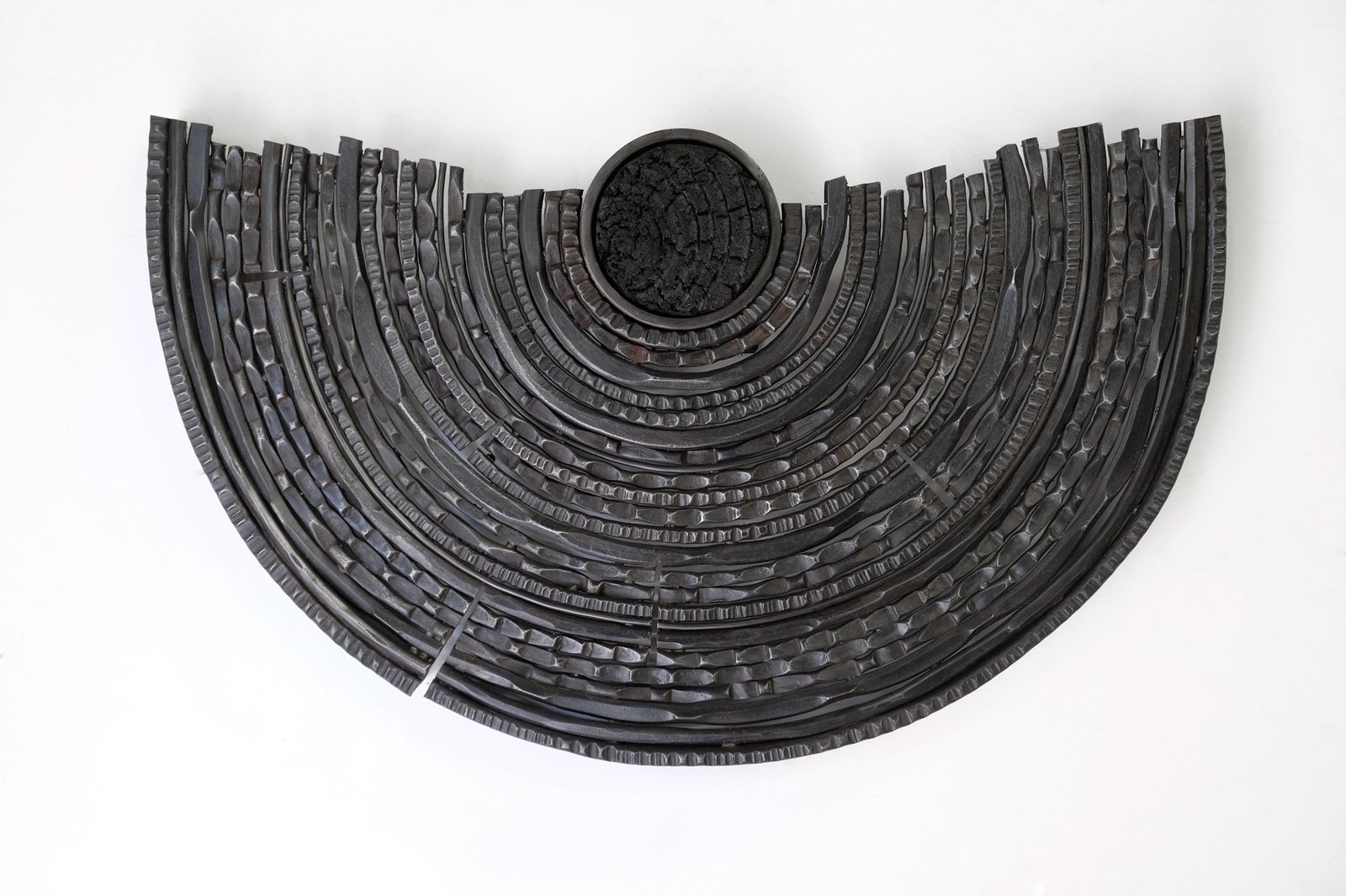 Carbon Record by Maria Cristalli — wall piece with vertical forged elements and wood circle