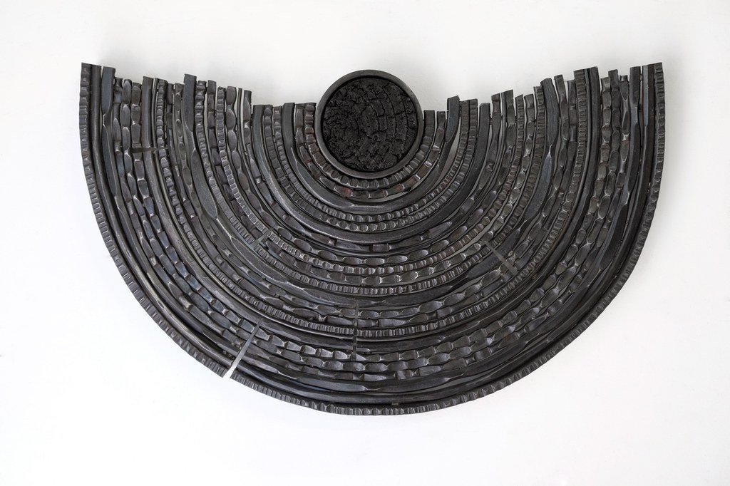 Carbon Record by Maria Cristalli — forged iron concentric semicircles with charred carbon center